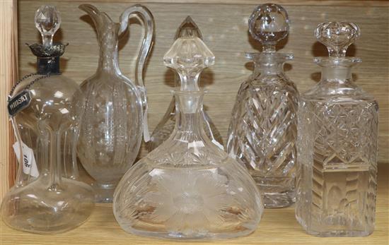 A dimple glass silver-mounted decanter with silver whisky label, a cut glass claret jug and four decanters and stoppers